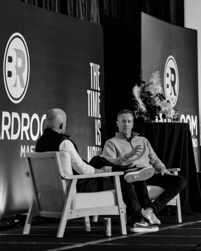 Luke Winter speaking on stage at the Boardroom Mastermind